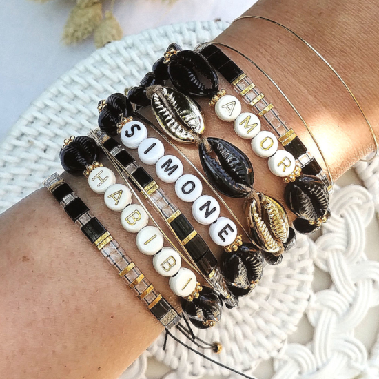 accumulation bracelets tendance mot ou prénom personnalisble coquillage cauri noir et or bracelets perles plates en verre japonaises